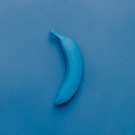 Blue banana on blue pastel background. Minimal style. Food concept. Flat lay.の写真素材