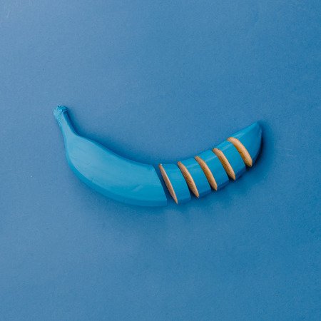 Blue banana on blue pastel background. Minimal style. Food concept. Flat lay.の写真素材