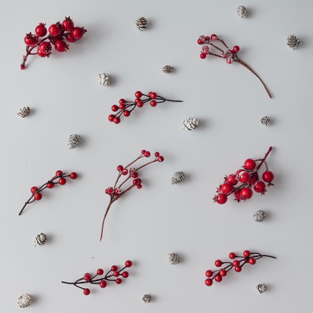 Creative bright pattern made of branches with red berries and pine cones. Christmas concept. Flat lay.の写真素材