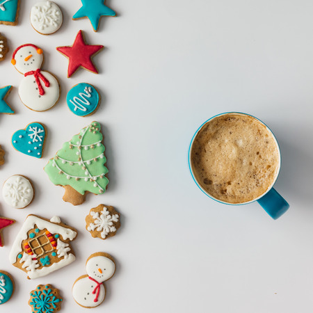 Colorful pattern made of Christmas cookies and red berries with coffee cup. Flat lay holiday concept.の写真素材