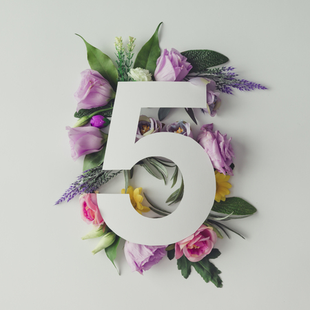 Creative layout with colorful flowers, leaves and number five. Anniversary concept.Flat lay.の写真素材