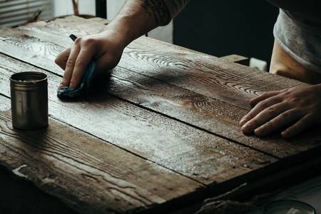 Hard working male hands cleaning or polishing wooden deskの写真素材