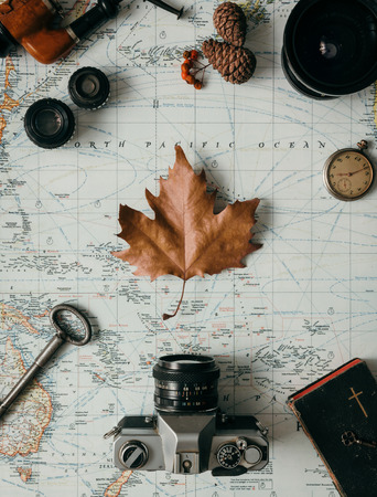 Flat lay adventure vintage gear for exploring or traveling on old mapの写真素材