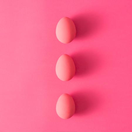 Top view of three pink Easter eggs on pink backgroundの写真素材