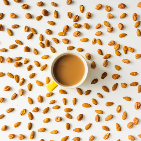 Colourful bright pattern made of almonds with coffee cup. Flat lay.の写真素材