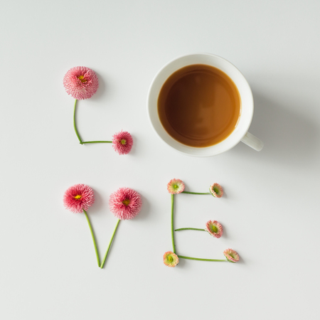 "Love" made of flowers and coffee cup on white background. Love concept. Flat lay.の写真素材