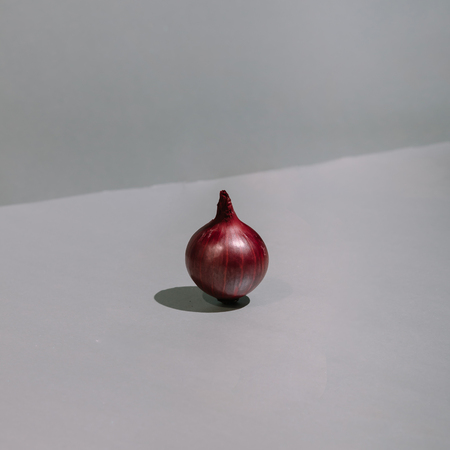 Red onion cut in half on kitchen table.  Minimal concept.の写真素材