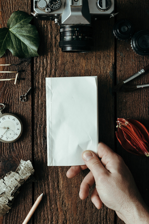 POV male holding paper note on old wooden table. Flat layの写真素材