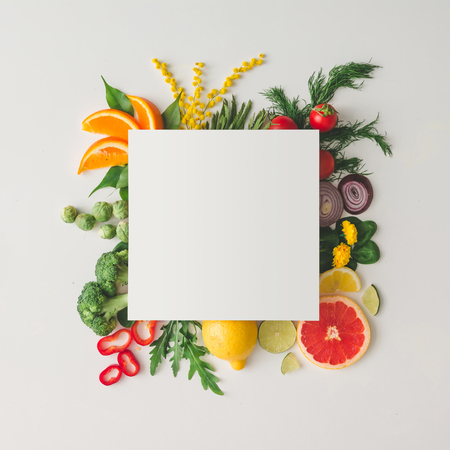 Creative layout made of various fruits and vegetables with white paper card. Flat lay. Food concept.の写真素材