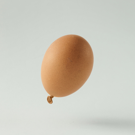 Egg balloon on bright white background. Minimal creative concept. Flat lay.の写真素材