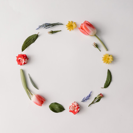 Round frame made of colorful spring flowers and leaves. Flat lay. Nature concept.の写真素材