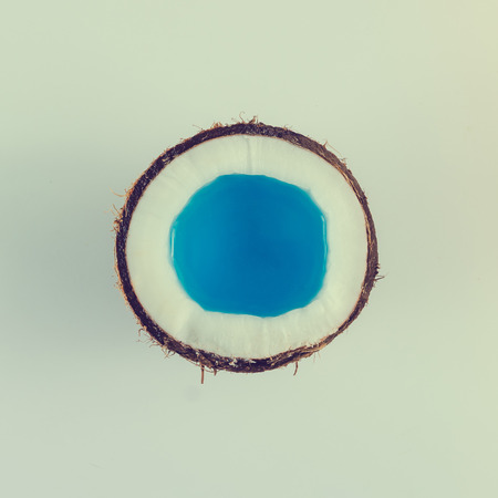 Coconut close up with blue water on bright  background. Minimal summer concept. Flat lay.の写真素材
