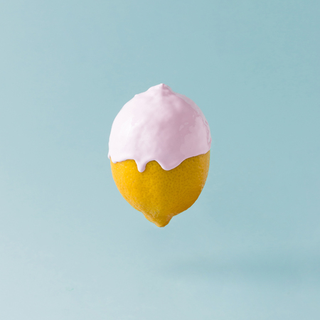 Lemon with ice cream topping on pastel blue background. Food creative concept.の写真素材