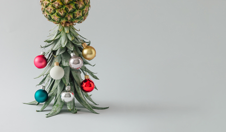 Christmas tree made of pineapple and christmas bauble decoration. Holiday concept.の写真素材