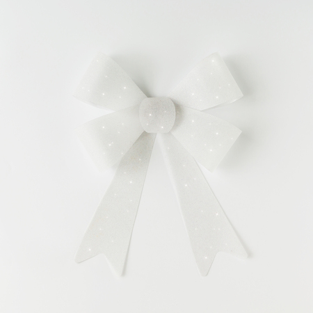Minimal white gift bow on bright background. Flat lay.の写真素材