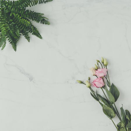 Creative natural composition made of flowers and leaves on marble background. Flat lay. Love concept.の写真素材