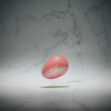 Holographic Easter egg on marble background. Minimal Easter holiday concept.の写真素材
