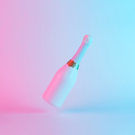 White champagne bottle with colorful ultraviolet holographic neon lights. Creative concept.の写真素材