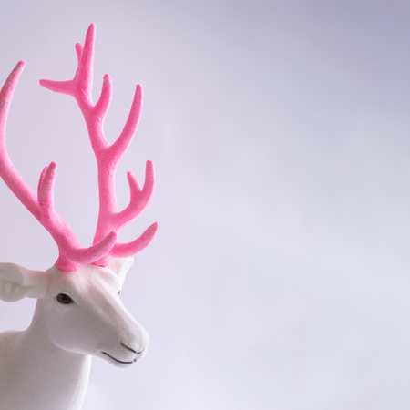 White reindeer with glitter pink antlers. Minimal New Year or Christmas background concept.の写真素材