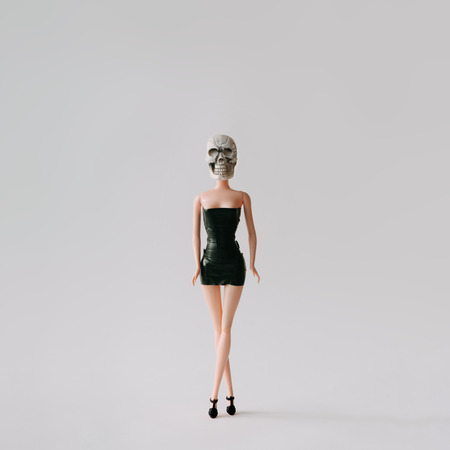 Girl doll with skull head. Minimal concept.