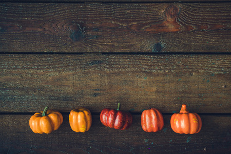 Creative layout of colorful pumpkins against wooden background. Halloween concept.の写真素材