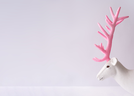 White reindeer with glitter pink antlers. Minimal New Year or Christmas background concept.の写真素材