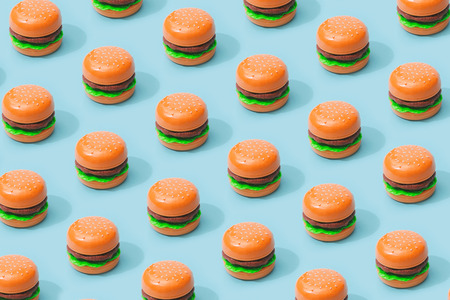 Hamburger fast food pattern on pastel blue background. Minimal junk food concept.の写真素材