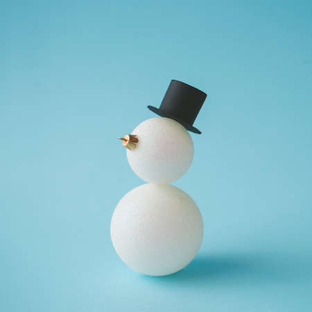 Snowman made of Christmas bauble decoration on pastel blue background. Creative winter concept.の写真素材