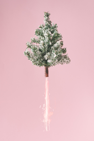 Christmas tree with fireworks against pastel pink background. New year countdown concept. Christmas tree rocket.の写真素材