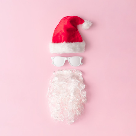 Santa Claus portrait with hipster sunglasses on pink background with copy space. Minimal flat lay Christmas theme. New year sale concept.の写真素材