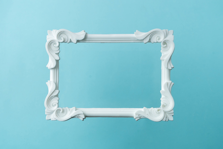 White vintage frame on pastel blue background. Minimal border composition.