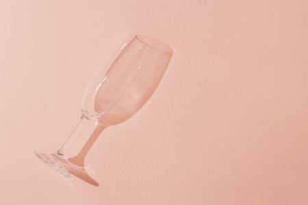 Minimal style. Champagne glass on pastel coral background.の写真素材