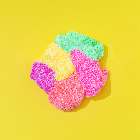 Colorful slime on bright yellow background. Minimal creative art concept.の写真素材