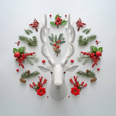 Christmas flat lay layout with Santa deer and natural decoration. Creative Holiday concept. Reindeer minimal background.の写真素材