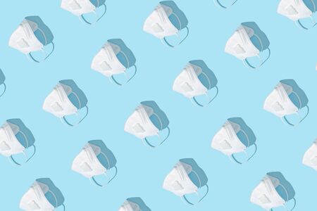 Respiratory or surgical face mask. Coronavirus or COVID-19 protection on blue background. Pandemic or epidemic pattern concept.の写真素材