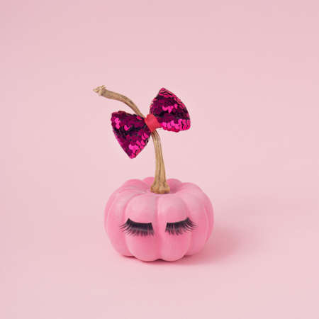 Pink Halloween pumpkin with make up. Minimal Holiday season concept background.の写真素材