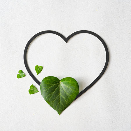 Love valentines concept. Heart shape leaves with paper card note. Minimal flat lay green background....