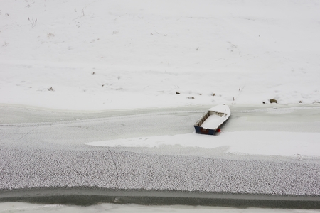 Frozen wooden boat on river Vuka in Croatia.の写真素材