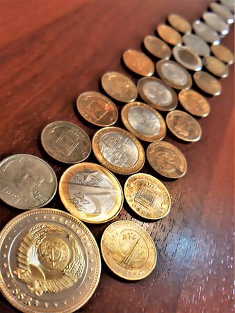 iron coins of different denominations and different colors are scattered on the tableの写真素材