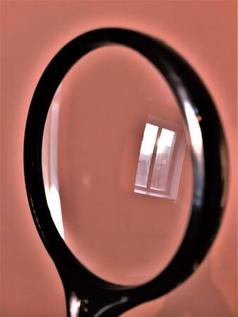 reflection of a window on a pink wall through a magnifierの写真素材