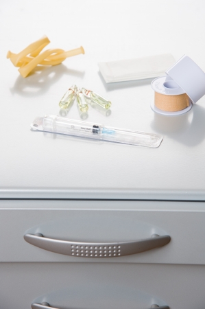 medical objects with syringe on a metal cabinetの写真素材