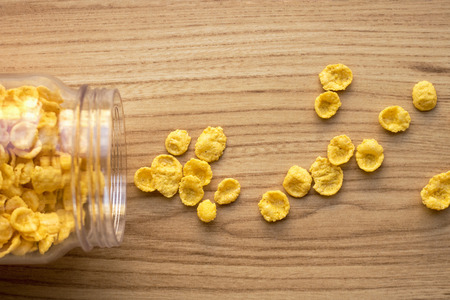 cornflakes in a bottle with scattered grainsの写真素材