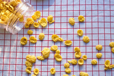 cornflakes in a bottle with grains scattered around