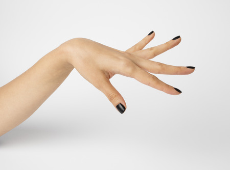 Female hand with black nails, isolated on white background. Shallow depth photography.の写真素材
