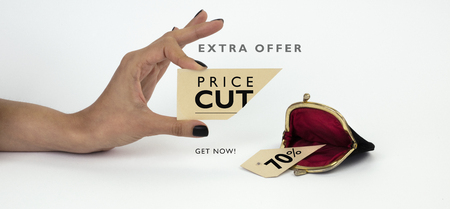 Black Friday banner. Female hand holding a cut price tag with opened vintage wallet below â cut piece below. Isolated on white background.の写真素材