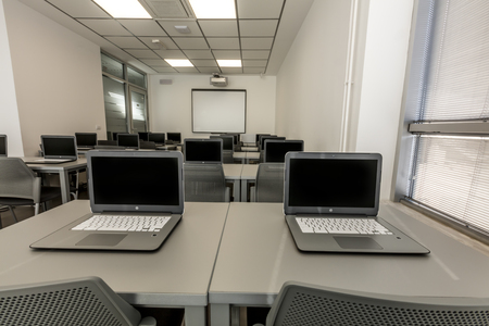 Modern office, work desks with laptops. In depth photography.