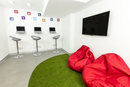 Modern waiting, or lounge room; laptops, TV and beanbags in the background.の写真素材