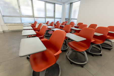 Modern classroom interior, with white board and movable tables and chairs. Theater style setting.の写真素材