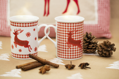 Christmas composition â mugs with deer motive, cinnamon sticks, anise and pinecones.の写真素材