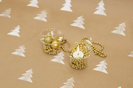 Christmas composition â golden ornaments and lit candle in glass candle holders.の写真素材